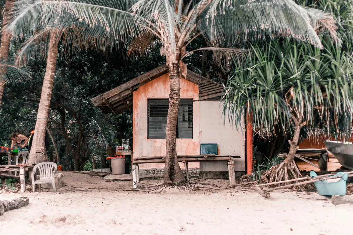 A palm-shaded beach hut on the sand in Siquijor, Philippines